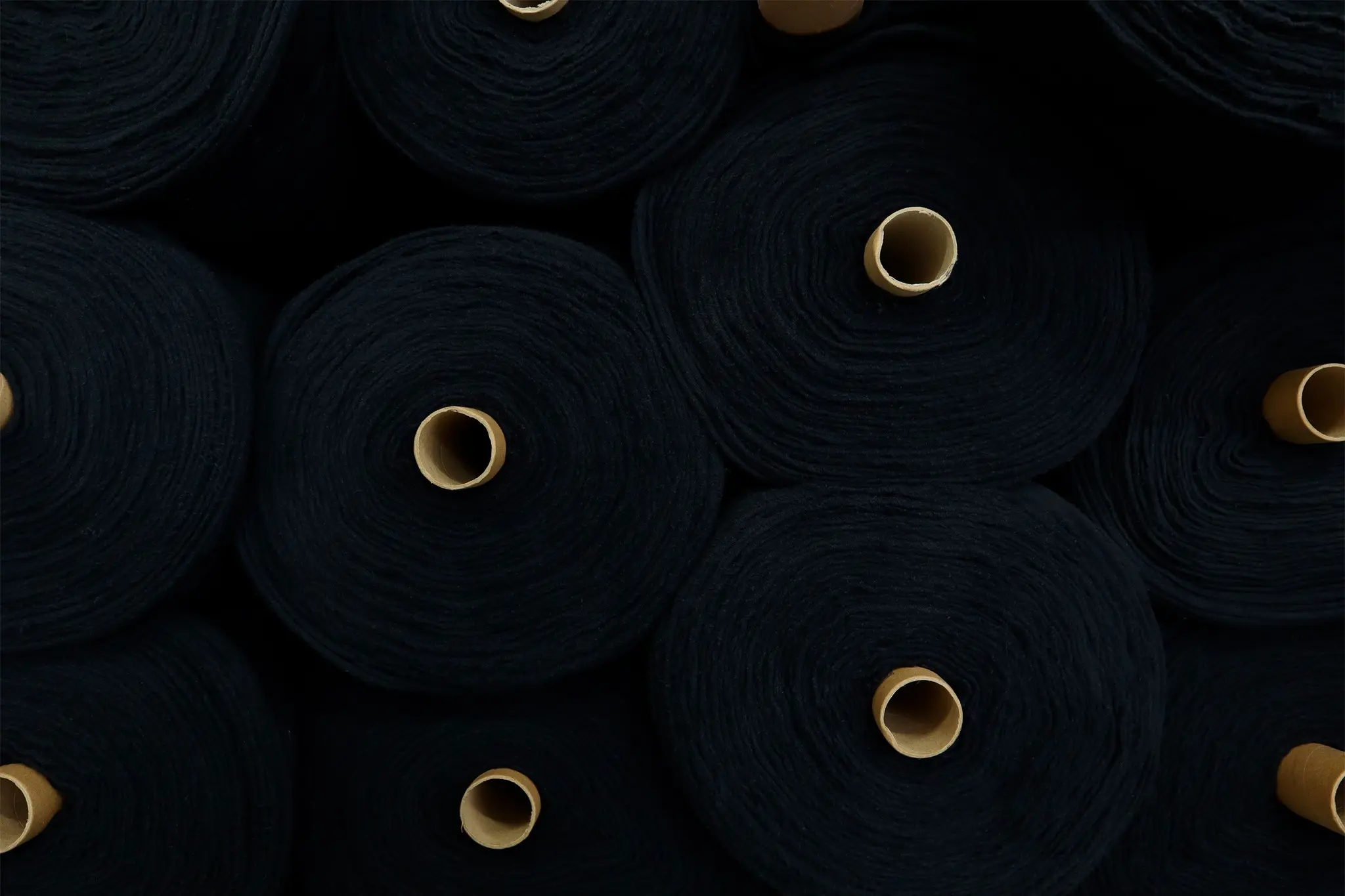 Rolls of black textile material prepared for production